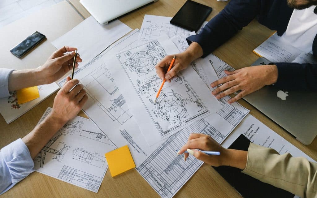 Colleagues examining technical drawings on paper