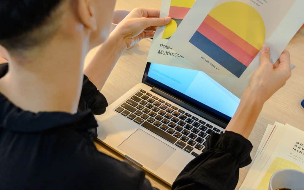 Designer working with brand colour swatches and a laptop