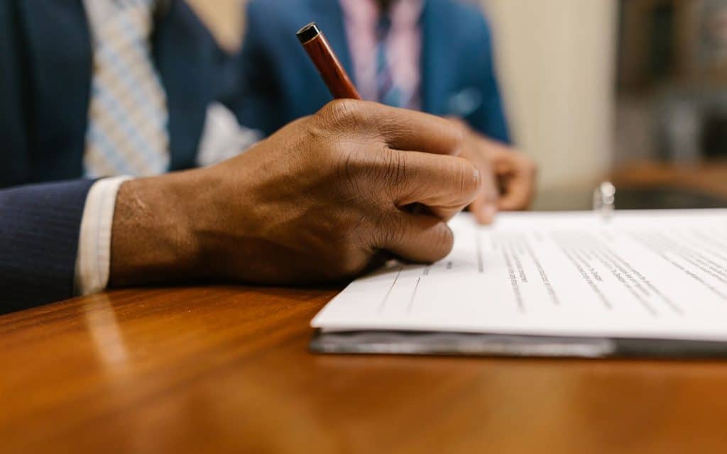Person writing on a contract