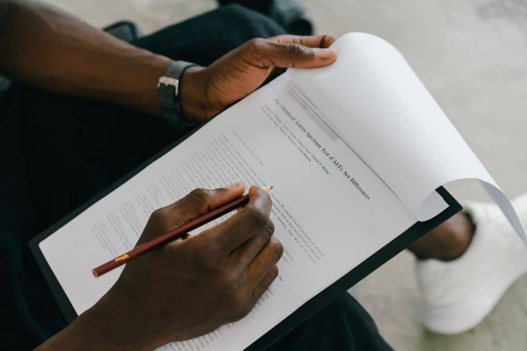 Reviewer checking a printed document with a pen