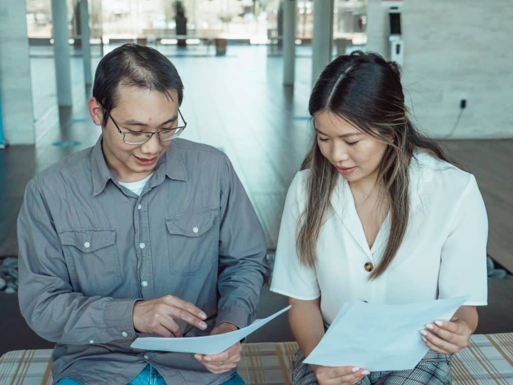 Two colleagues reviewing a translation on a laptop