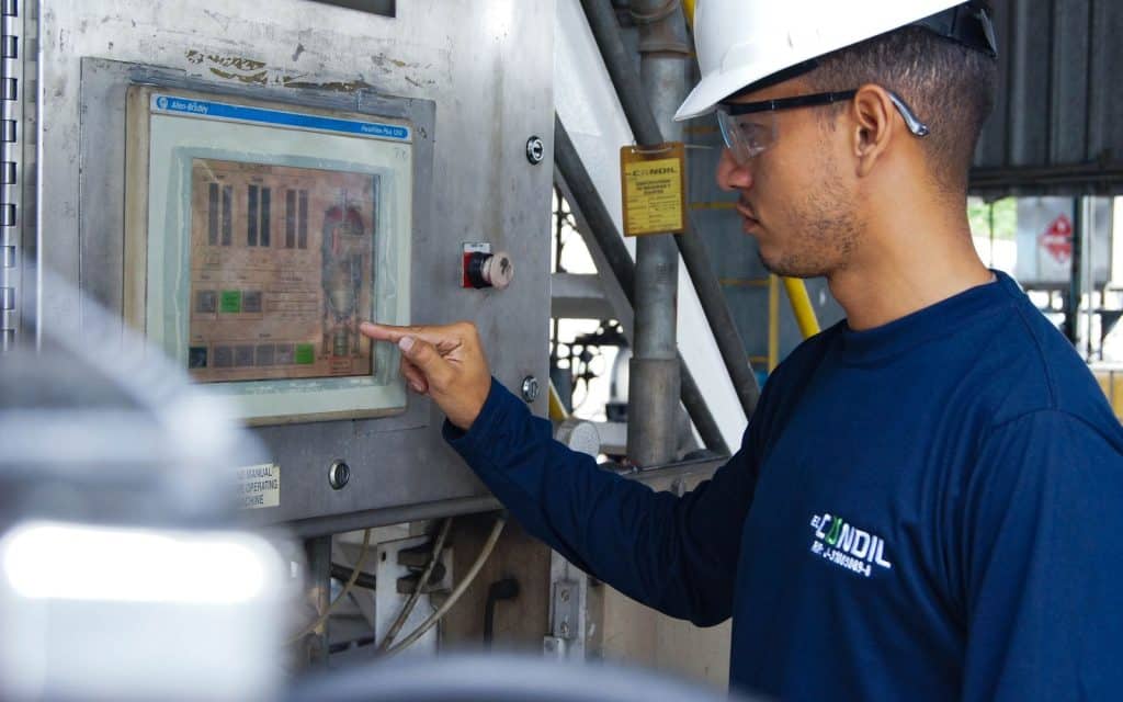 Worker operating an industrial control panel