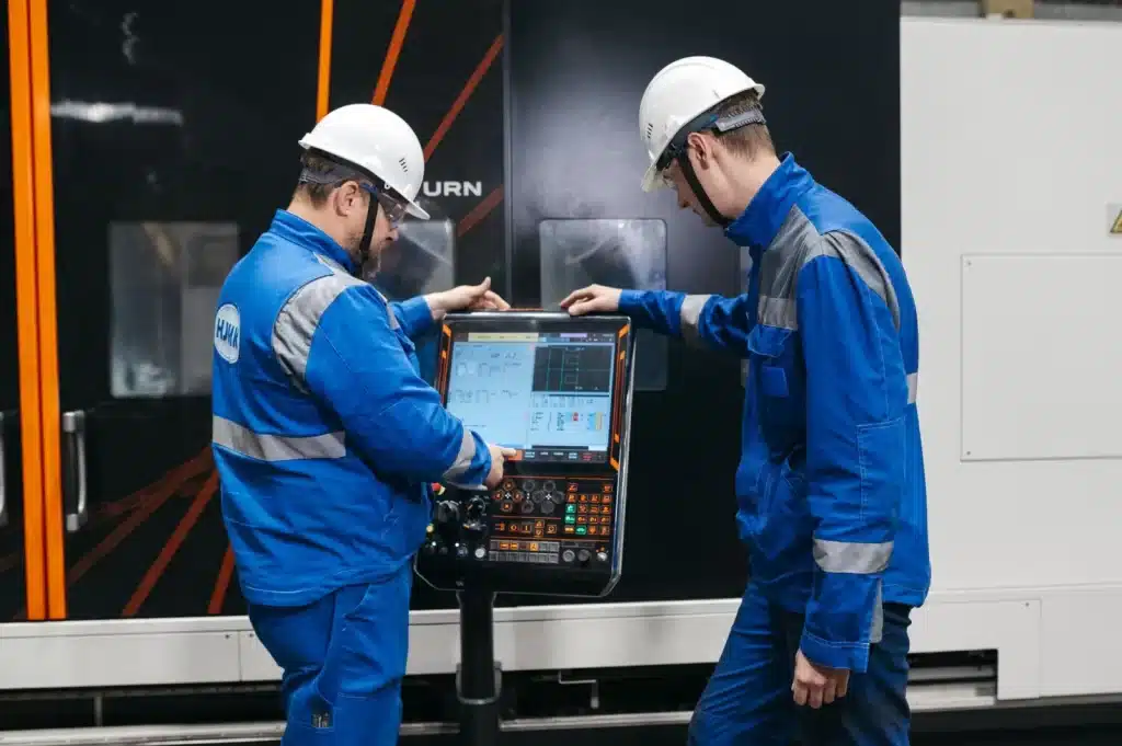 Engineers operating CNC machinery in a manufacturing plant